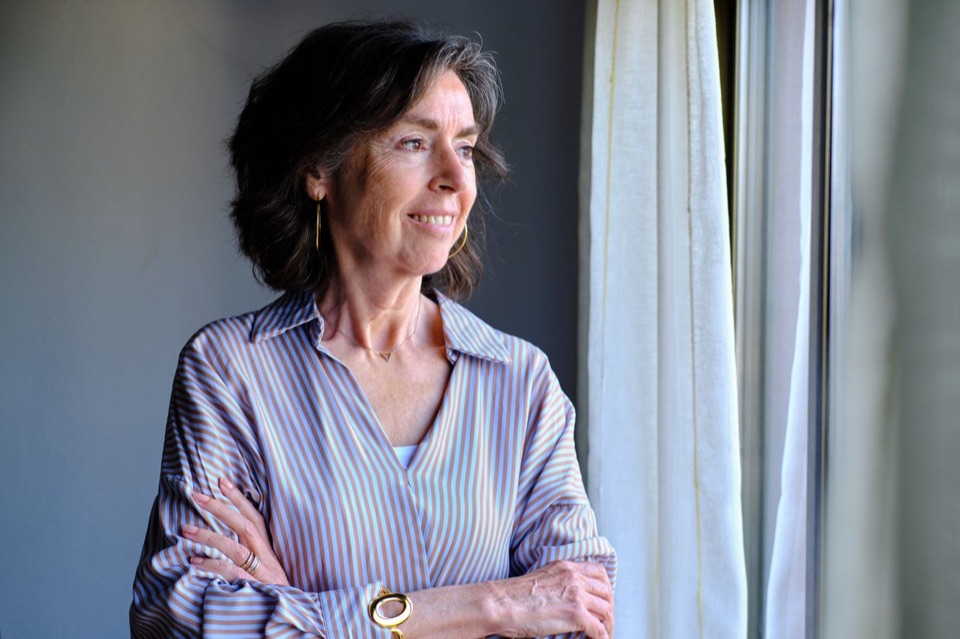 Woman smiling by a window at home