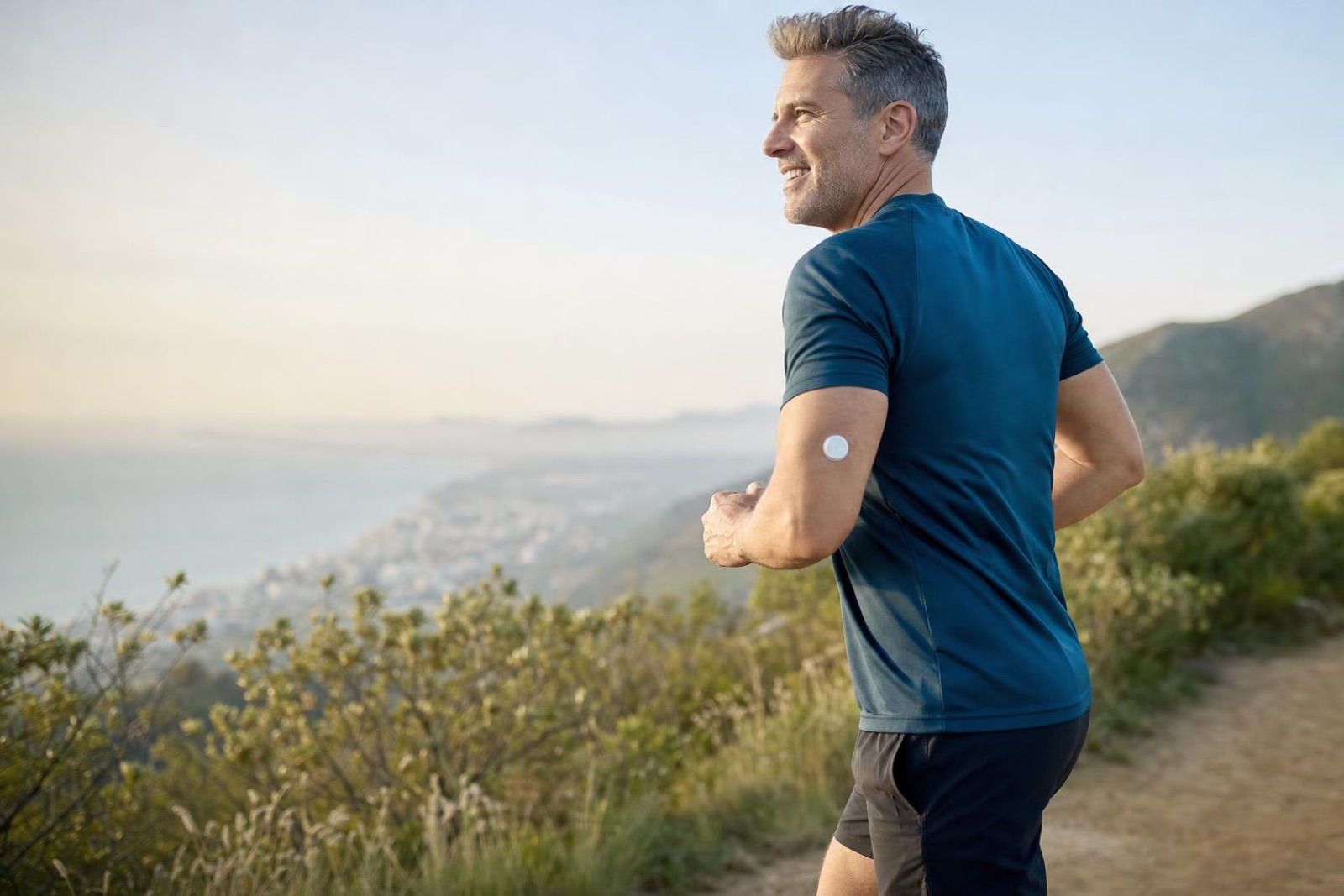 Man and woman in their 40s walking briskly on a coastal path